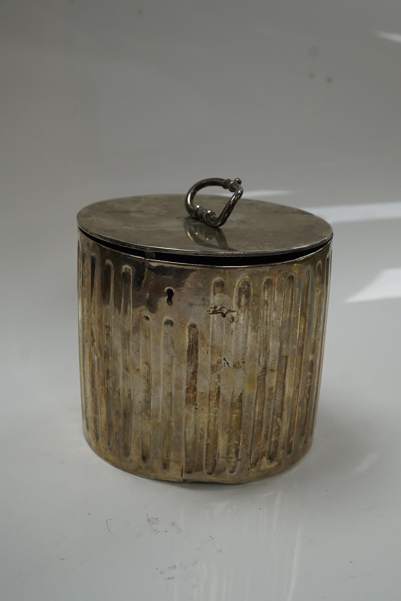 A George III fluted silver lead lined circular tea caddy, by Walter Tweedie, London, 1772, height 10cm excluding handle. Condition - poor